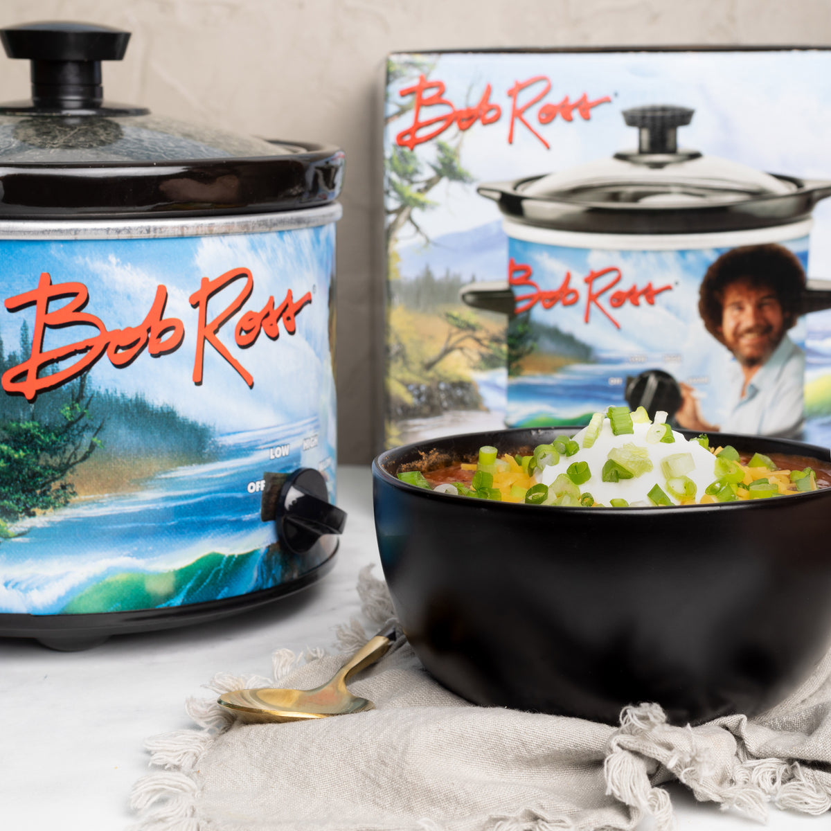 Bob Ross slow cooker on counter with chili. Product box in in the background